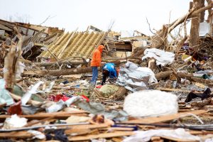 Workers pick through debris scattered following a deadly tornado in Joplin, MO.