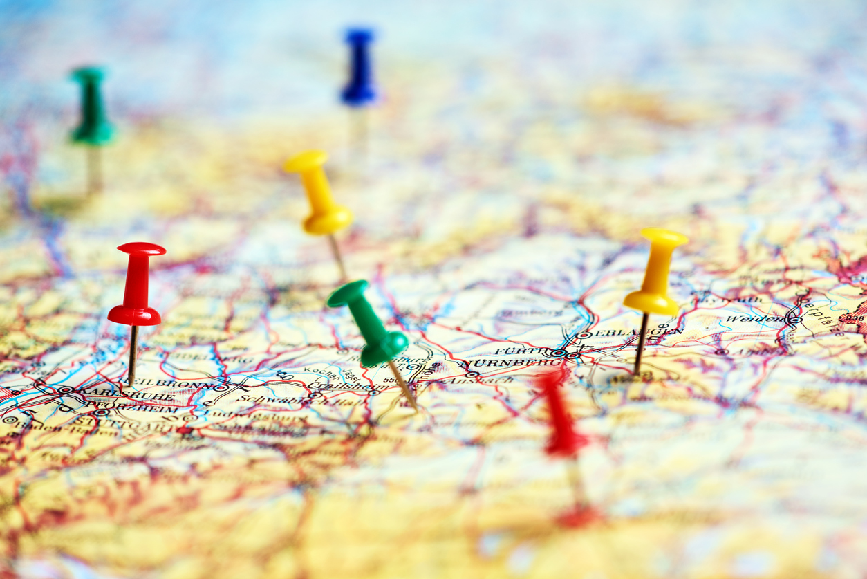 Colorful pins marking different destinations on a paper map.