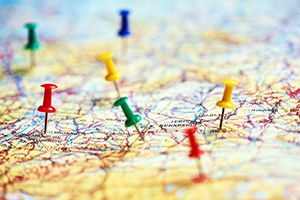 Colorful pins marking different destinations on a paper map.