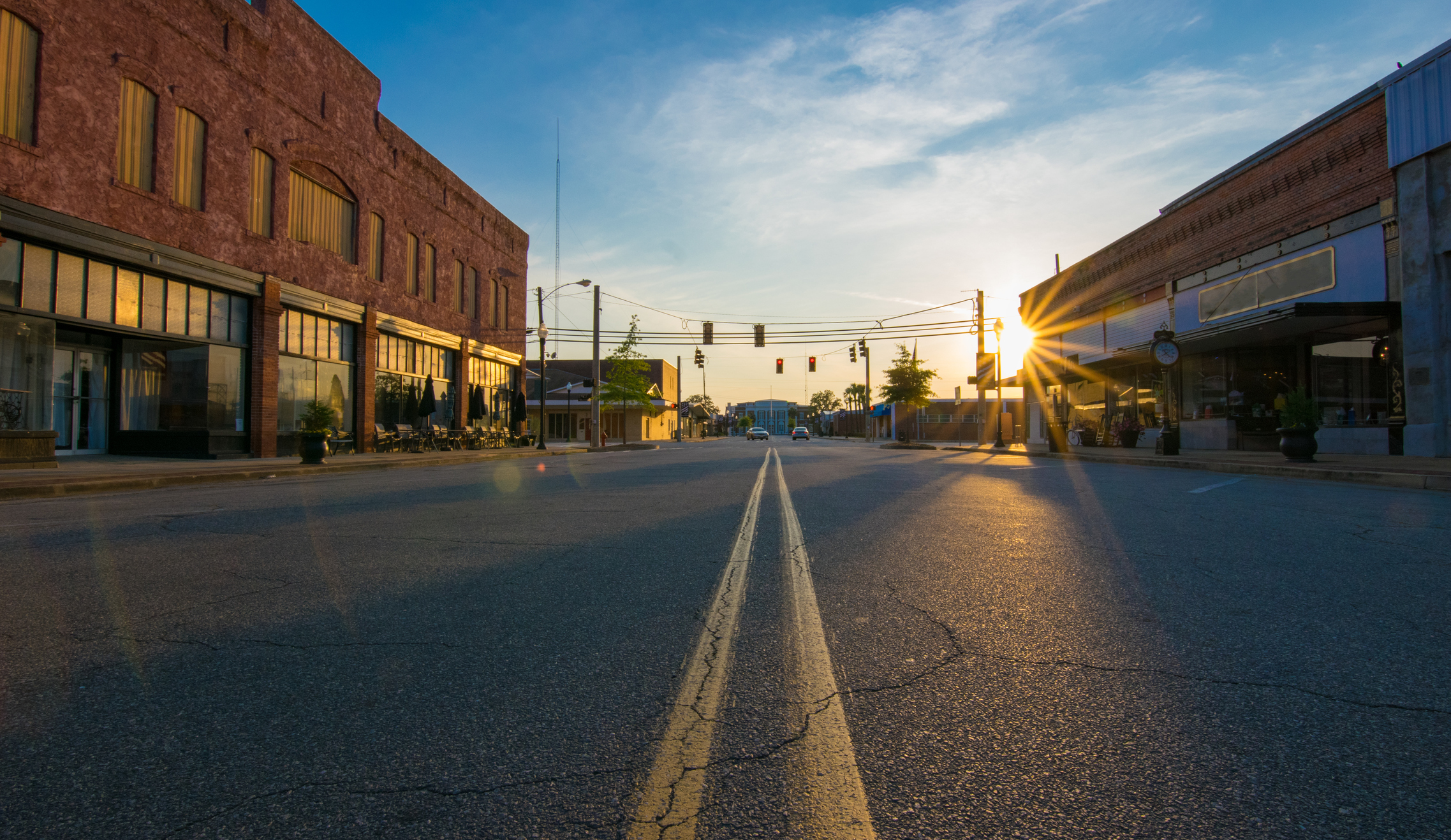 Storefronts at sunset in the middle of an empty road in downtown in a small town.