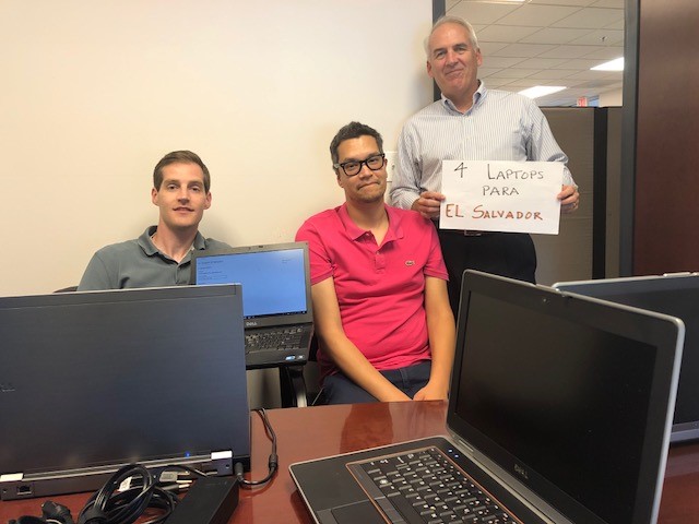 IBTS IT team members sit behind a desk.